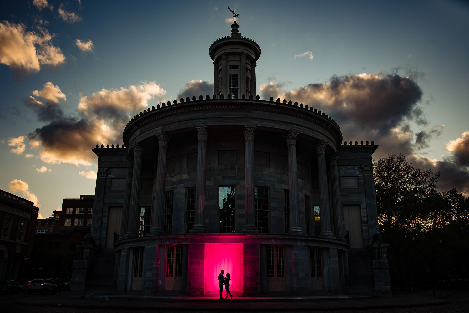 A dramatic engagement photo against a sunset sky