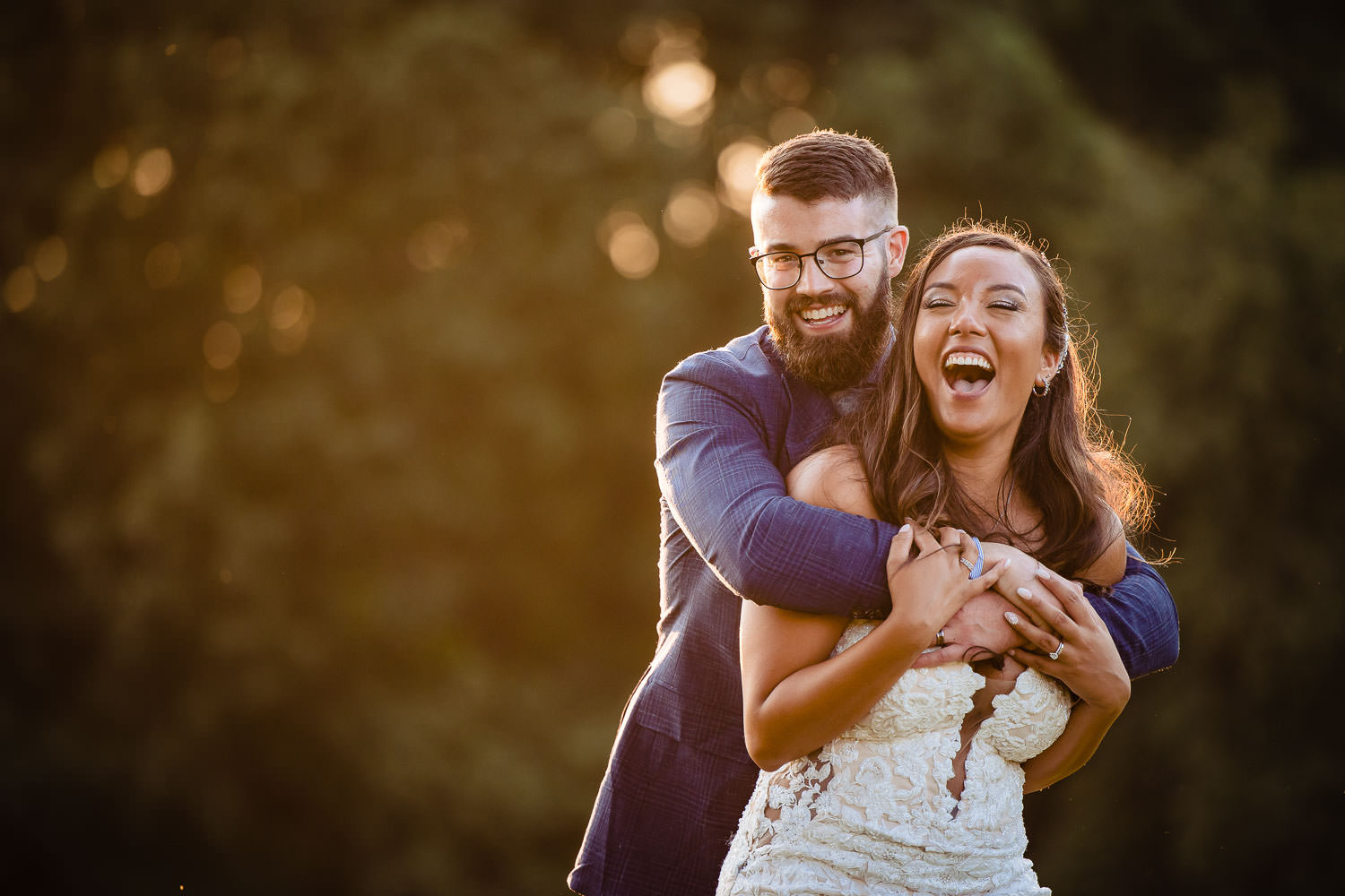 A bride and groom laughing together on their wedding day